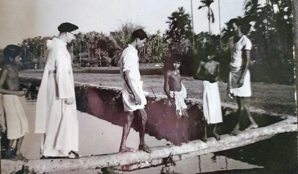 El padre Marcelino Iragui cruza un río junto a un grupo de jóvenes en la India