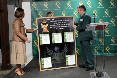 El teniente coronel jefe de Tráfico, Agustín Aznárez, entrega a Sarai Rodríguez un cuadro homenaje con los agentes de Tráfico fallecidos en Navarra