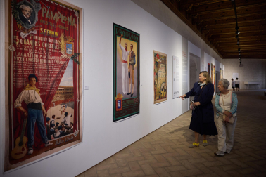 Dos visitantes ven los carteles de 1908, de Javier Ciga, y de 1945, de Crispín Martínez