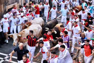 La manada de La Palmosilla, rodeada de mozos en el tramo de la Estafeta durante el `primer encierro de los Sanfermines 2024