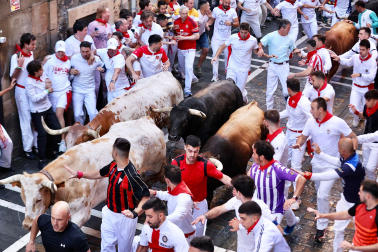 La manada de La Palmosilla, rodeada de mozos en el tramo de la Estafeta durante el `primer encierro de los Sanfermines 2024
