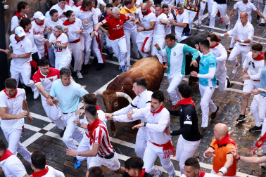La manada de La Palmosilla, rodeada de mozos en el tramo de la Estafeta durante el `primer encierro de los Sanfermines 2024