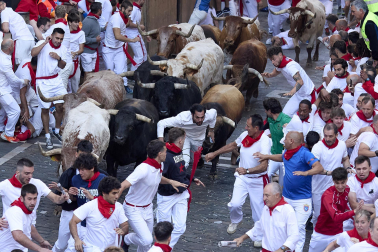 Los mozos corren junto a los morlacos de La Palmosilla en el tramo de la Plaza del Ayuntamiento durante el primer encierro de los Sanfermines 2024