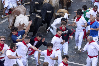 Los mozos corren junto a los morlacos de La Palmosilla en el tramo de la Plaza del Ayuntamiento durante el primer encierro de los Sanfermines 2024