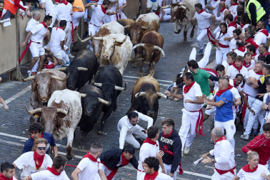 Los mozos corren junto a los morlacos de La Palmosilla en el tramo de la Plaza del Ayuntamiento durante el primer encierro de los Sanfermines 2024