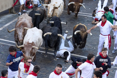 Los mozos corren junto a los morlacos de La Palmosilla en el tramo de la Plaza del Ayuntamiento durante el primer encierro de los Sanfermines 2024