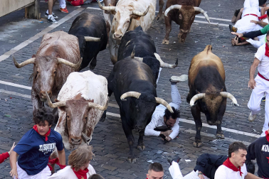Los mozos corren junto a los morlacos de La Palmosilla en el tramo de la Plaza del Ayuntamiento durante el primer encierro de los Sanfermines 2024