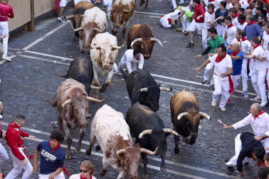 Los mozos corren junto a los morlacos de La Palmosilla en el tramo de la Plaza del Ayuntamiento durante el primer encierro de los Sanfermines 2024