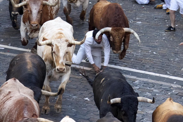 Los mozos corren junto a los morlacos de La Palmosilla en el tramo de la Plaza del Ayuntamiento durante el primer encierro de los Sanfermines 2024