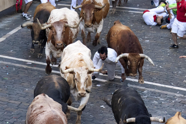 Los mozos corren junto a los morlacos de La Palmosilla en el tramo de la Plaza del Ayuntamiento durante el primer encierro de los Sanfermines 2024