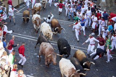 Los mozos corren junto a los morlacos de La Palmosilla en el tramo de la Plaza del Ayuntamiento durante el primer encierro de los Sanfermines 2024