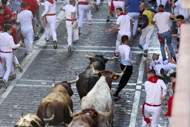 Los mozos corren junto a los morlacos de La Palmosilla en el tramo de la Plaza del Ayuntamiento durante el primer encierro de los Sanfermines 2024