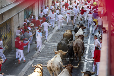 Los mozos corren junto a los morlacos de La Palmosilla en el tramo de la Plaza del Ayuntamiento durante el primer encierro de los Sanfermines 2024