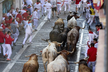 Los mozos corren junto a los morlacos de La Palmosilla en el tramo de la Plaza del Ayuntamiento durante el primer encierro de los Sanfermines 2024