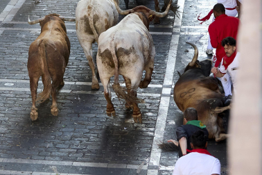 Los mozos corren junto a los morlacos de La Palmosilla en el tramo de la Plaza del Ayuntamiento durante el primer encierro de los Sanfermines 2024