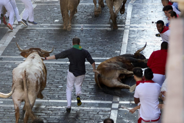 Los mozos corren junto a los morlacos de La Palmosilla en el tramo de la Plaza del Ayuntamiento durante el primer encierro de los Sanfermines 2024