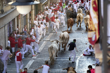 Los mozos corren junto a los morlacos de La Palmosilla en el tramo de la Plaza del Ayuntamiento durante el primer encierro de los Sanfermines 2024