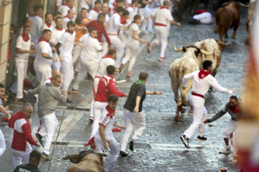 Los mozos corren junto a los morlacos de La Palmosilla en el tramo de la Plaza del Ayuntamiento durante el primer encierro de los Sanfermines 2024