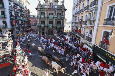 Los mozos corren junto a los morlacos de La Palmosilla en el tramo de la Plaza del Ayuntamiento durante el primer encierro de los Sanfermines 2024