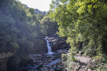 Varios turistas bañándose en la cascada de Ixkier, por la que transita el río Larraun y paraje al que se llega a través de la vía verde del Plazaola, principal punto de interés tanto para vecinos como personas que visitan Lekunberri