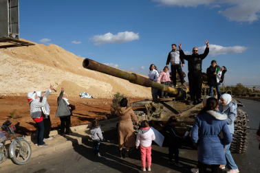 Una familia celebra la caída del régimen en un tanque abandonado en Damasco.