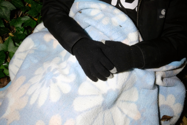 Unos guantes de lana, un gorro, una manta y un saco es todo lo que le protege de las temperaturas gélidas que acuchillan días navideños en Pamplona.