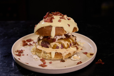 creación de los clientes y seguidores de Gastro Okei Errialde, Foodie Team. Carne con doble de queso cheddar, salsa Romero’s House, cebolla caramelizada, queso rulo de cabra, bacon crujiente y más salsa por encima del pan (opcional).