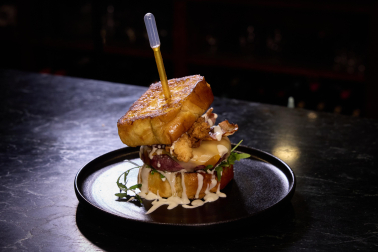 Idea del jefe de Gastro Okei Errialde con inspiración estadounidense, Fermín Team. En french toast, carne con doble de queso, rúcula, salsa ranchera con queso azul, bacon ahumado, pollo frito y salsa hot honey (miel picante).