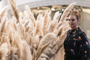 La artista Monika Aranda rodeada de plumeros de la Pampa