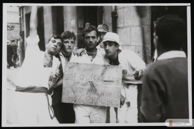 Unos mozos en los Sanfermines de 1965 con un cartel que dice: "Si quiere ser mi amigo, no me hable del Cordobés"