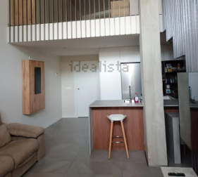 Cocina y salón bajo la sobreplanta del loft disponible en Arrosadía