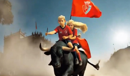 A lomos de un toro, Rojillo y Rojilla cabalgan por las calles de Pamplona con la bandera del C.A. Osasuna /