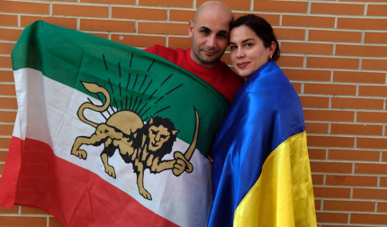 Elena y Sami, con las banderas de sus países, Ucraniana e Irán, en el barrio pamplonés de la Rochapea