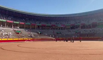 Los areneros riegan la arena de la plaza de toros antes de la corrida del 9 de julio