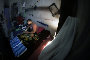 Son las diez de la noche. La habitación donde sobrevive, como todas en el edificio abandonado, está cerrada con cadenas para evitar ocupaciones. Dentro, un colchón sobre el suelo, un espejo roto y un cubo con agua de pozo para asearse. Ishak se sienta y devora en silencio un bocadillo de tortilla con bonito que le ha proporcionado una voluntaria de Apoyo Mutuo. “Es lo primero que como en un día y medio”, dice sin mostrar aflicción.