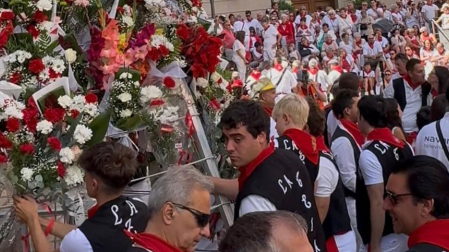 Los miembros de la peña La Teba se encargan de recorrer los ramos de flores y colocarlos en la estructura colocada bajo la imagen de la patrona de Tudela