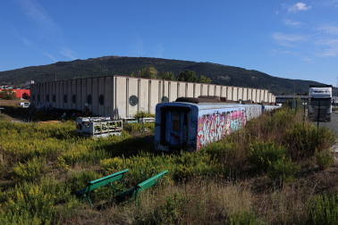 Bancos recién pintados al sol junto al tren abandonado, al fondo el monte Ezkaba.