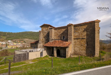 Fachada con la puerta de entrada a la iglesia y el pequeño cementerio colindante