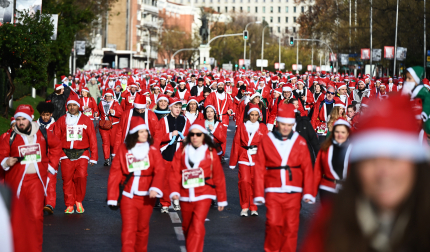 Participantes de todas las edades recorren el centro de Madrid vestidos de papá noeles durante la 14ª edición de la Carrera de Papá Noel
