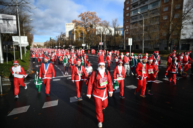 Participantes de todas las edades recorren el centro de Madrid vestidos de papá noeles durante la 14ª edición de la Carrera de Papá Noel, este domingo 21 de diciembre
