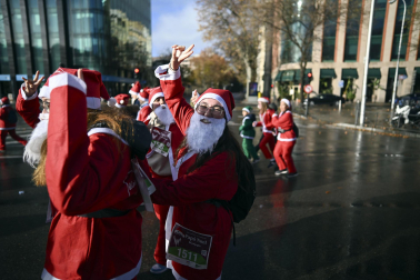 Participantes de todas las edades recorren el centro de Madrid vestidos de papá noeles durante la 14ª edición de la Carrera de Papá Noel, este domingo 21 de diciembre