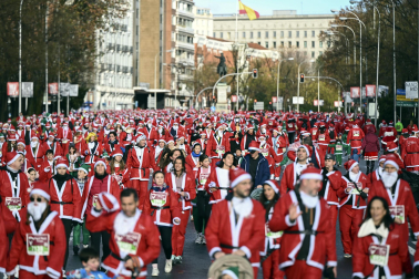 Participantes de todas las edades recorren el centro de Madrid vestidos de papá noeles durante la 14ª edición de la Carrera de Papá Noel, este domingo 21 de diciembre