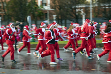 Participantes de todas las edades recorren el centro de Madrid vestidos de papá noeles durante la 14ª edición de la Carrera de Papá Noel, este domingo 21 de diciembre