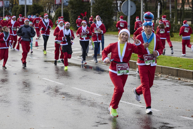 Participantes de todas las edades recorren el centro de Madrid vestidos de papá noeles durante la 14ª edición de la Carrera de Papá Noel, este domingo 21 de diciembre