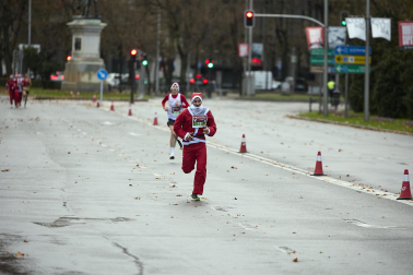 Participantes de todas las edades recorren el centro de Madrid vestidos de papá noeles durante la 14ª edición de la Carrera de Papá Noel, este domingo 21 de diciembre