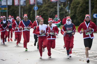 Participantes de todas las edades recorren el centro de Madrid vestidos de papá noeles durante la 14ª edición de la Carrera de Papá Noel, este domingo 21 de diciembre