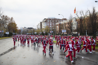 Participantes de todas las edades recorren el centro de Madrid vestidos de papá noeles durante la 14ª edición de la Carrera de Papá Noel, este domingo 21 de diciembre