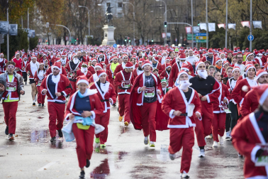 Participantes de todas las edades recorren el centro de Madrid vestidos de papá noeles durante la 14ª edición de la Carrera de Papá Noel, este domingo 21 de diciembre