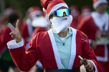Participantes de todas las edades recorren el centro de Madrid vestidos de papá noeles durante la 14ª edición de la Carrera de Papá Noel, este domingo 21 de diciembre