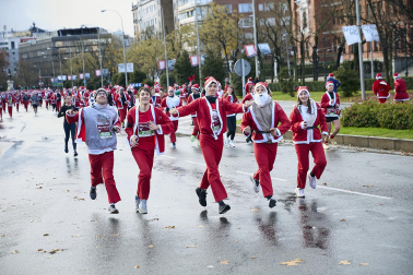 Participantes de todas las edades recorren el centro de Madrid vestidos de papá noeles durante la 14ª edición de la Carrera de Papá Noel, este domingo 21 de diciembre